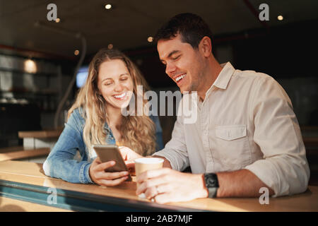 Schönes Lächeln junges Paar am Tag genießen Sie die mobile Apps im Coffee shop Counter Stockfoto