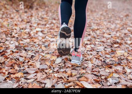 In der Nähe der Füße ein Läufer läuft im Herbst Blätter in Park Stockfoto