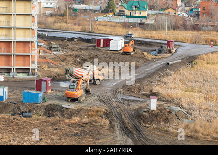 Details der Baustelle. schwerer Industriemaschinen arbeitet auf einer Baustelle: Betonmischer, Maschinen, Bulldozer, Ausgrabung, Werk Stockfoto