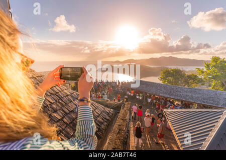 Frau nimmt Bilder mit Smartphone bei Sonnenuntergang Partei, Shirley Heights, Antigua, Antigua und Barbuda, Karibik, Karibik, Zentral- und Lateinamerika Stockfoto