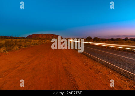 Auto Licht Spuren auf dem Weg zum Uluru (Ayers Rock) bei Nacht, Outback, Red Centre, Uluru-Kata Tjuta National Park, UNESCO, Australien Stockfoto