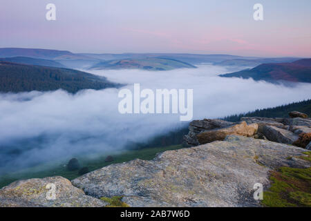 Dawn Licht bricht über den Peak District Hügel mit einer Wolke Inversion die Ladybower Reservoir, Peak District, Derbyshire, Großbritannien Stockfoto