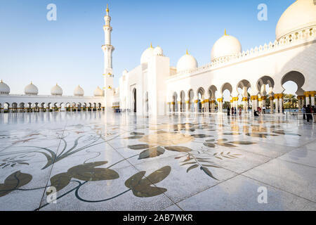 Die Kuppeln und Minarette von Abu Dhabi Grand Moschee gesehen über den großen gefliesten Marmorboden, zentralen Innenhof, Abu Dhabi, Vereinigte Arabische Emirate Stockfoto