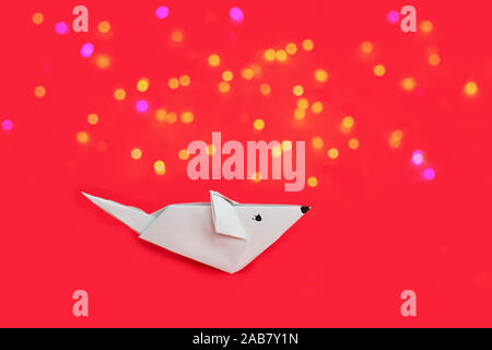 Cute white origami Papier Ratte und auf rotem Hintergrund. Stockfoto