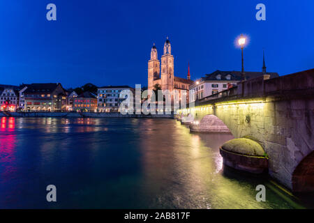 Beleuchteten Gebäuden der Limmatkai und Grossmünster in der Dämmerung von Munsterbrucke Brücke, Zürich, Schweiz, Europa Stockfoto