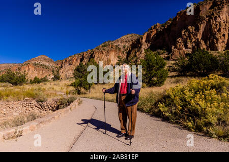 Alter Mann zu Fuß durch die Pueblo Indian Ruinen im Bandelier National Monument, New Mexico, Nordamerika Stockfoto