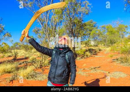 Ihnen gerne touristische Frau mit einem frühen Waffe der Boomerang von luritja und Pertame Menschen in Zentral- Australien, Australien Stockfoto