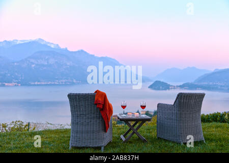 Sessel und Rotwein mit Blick auf den Comer See bei Sonnenuntergang, Lombardei, Italienische Seen, Italien, Europa Stockfoto