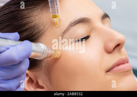 Makro Nahaufnahme der Therapeut Enzyme injiziert und mit Derma Stift um Woman's Augen. Stockfoto