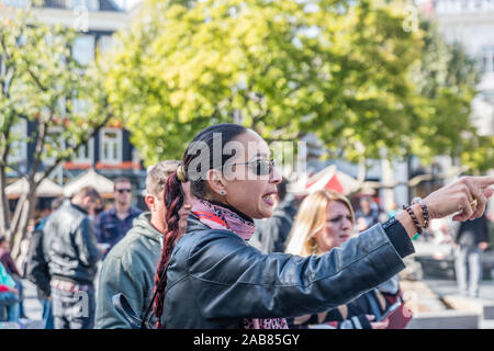 Amsterdam, Holland, September 2018 zu viele Touristen, die die Stadt Amsterdam Beweise dieser langen weiblichen Guide mit roten Regenschirm und lange leder j Stockfoto