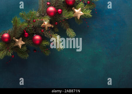 Tanne Zweig mit Weihnachten Dekoration auf einem dunklen Blau-grün lackierten Holz- Hintergrund. Flach. Weihnachten Hintergrund mit Platz für Text. Stockfoto