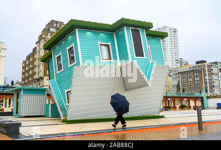 Brighton UK 26. November 2019 - ein Wanderer mit einem Regenschirm führt an der Oberseite nach unten Haus auf Brighton Seafront als die Reste des tropischen Sturms Sebastien in Großbritannien ankommen, starke Winde und Regen die meisten Teile des Landes. Foto: Simon Dack/Alamy leben Nachrichten Stockfoto