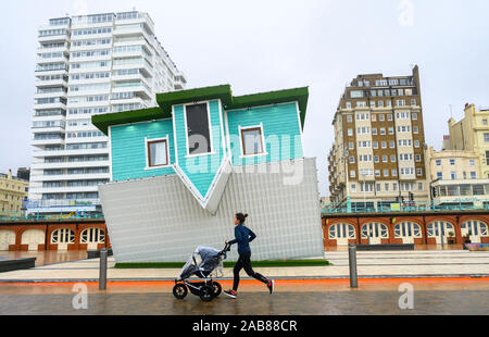 Brighton UK 26. November 2019 - ein Läufer geht durch den Kopf Haus auf Brighton Seafront als die Reste des tropischen Sturms Sebastien in Großbritannien ankommen, starke Winde und Regen die meisten Teile des Landes. Foto: Simon Dack/Alamy leben Nachrichten Stockfoto