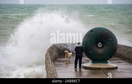 Brighton UK 26. November 2019 - ein Wanderer und sein Hund bekommt eine Tiefe von Wellen in Brighton Seafront als die Reste des tropischen Sturms Sebastien in Großbritannien ankommen, starke Winde und Regen die meisten Teile des Landes. Foto: Simon Dack/Alamy leben Nachrichten Stockfoto