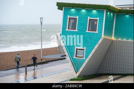 Brighton UK 26. November 2019 - ein Läufer geht durch den Kopf Haus auf Brighton Seafront als die Reste des tropischen Sturms Sebastien in Großbritannien ankommen, starke Winde und Regen die meisten Teile des Landes. Foto: Simon Dack/Alamy leben Nachrichten Stockfoto