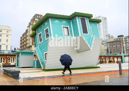 Brighton UK 26. November 2019 - ein Wanderer mit einem Regenschirm führt an der Oberseite nach unten Haus auf Brighton Seafront als die Reste des tropischen Sturms Sebastien in Großbritannien ankommen, starke Winde und Regen die meisten Teile des Landes. Foto: Simon Dack/Alamy leben Nachrichten Stockfoto