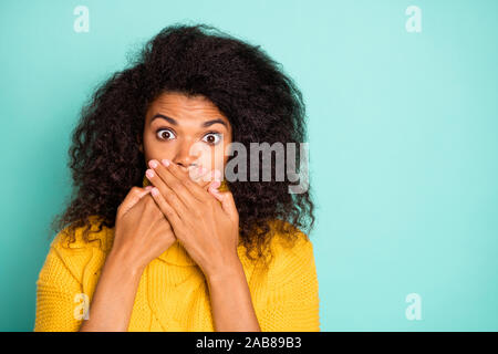 Ich habe kein Wort sagen. Nahaufnahme der ziemlich nervös dunkle Haut Dame in Stupor ausblenden Mund halten sich an den Händen in der Nähe von Lippen tragen gelbe gestrickte Pullover isoliert Stockfoto