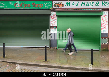 Abertillery, Wales, Großbritannien | 24. November 2019: Menschen zu Fuß vorbei an hohen Straße Geschäfte schließen mit Fensterläden geschlossen, der Rückgang der Einkaufen in Wales, Einheit Stockfoto