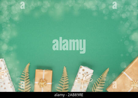 Festliche grüner Hintergrund mit gold Dekoration, Hintergrund mit Glitzer glänzenden goldenen Farnblätter und Geschenkboxen, Flach, Ansicht von oben, kopieren Raum Stockfoto