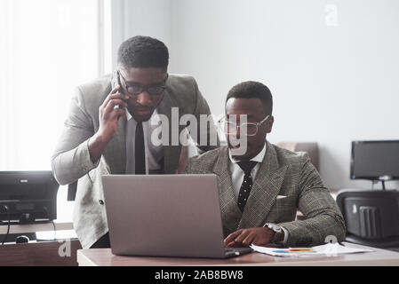 Bild des afrikanischen amerikanischen Geschäftsmanns, der auf seinem Laptop Stockfoto