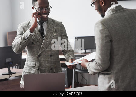 Das Bild der zwei junge afrikanische amerikanische Geschäftsleute, die an einer Sitzung im Büro interagieren Stockfoto