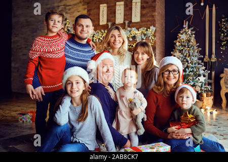 Glückliche Familie in einem Haus lächelnd mit einem Baum in Weihnachten. Stockfoto
