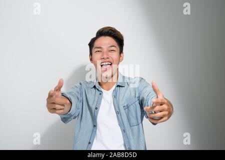 Asiatische heiter erregt Männer Freunde Jeans T-Shirt auf weißem Hintergrund, Daumen hoch Stockfoto