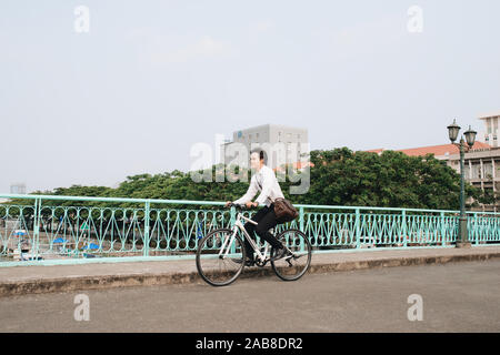 Überall von seinem Fahrrad. Seitenansicht der junge Unternehmer freuen uns auf dem Fahrrad Stockfoto