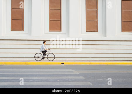 Überall von seinem Fahrrad. Seitenansicht der junge Unternehmer freuen uns auf dem Fahrrad Stockfoto