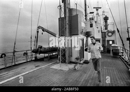 Piratenfunkstation Radio Laser 558 vor der Küste der Felixstowe Suffolk 1980er Jahre Großbritannien. Sie übertragen aus internationalen Gewässern in der Nordsee. DJ Ric Harris hält sich an Deck des Schiffes fit. 1984 England HOMER SYKES Stockfoto