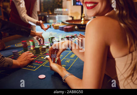 Chips in die Hände eines weiblichen Roulette Spieler im Casino Hintergrund. Stockfoto