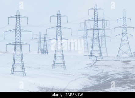 Strommasten holding Starkstrom Kabel im Winter Schnee hoch in den Lancashire Pennines Stockfoto