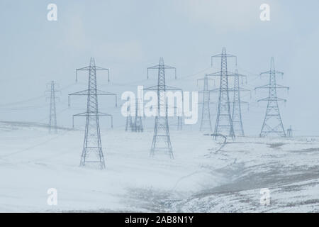 Strommasten holding Starkstrom Kabel im Winter Schnee hoch in den Lancashire Pennines Stockfoto