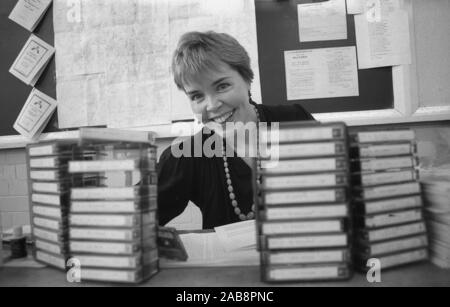 1980er Jahre, eine Forscherin an ihrem Schreibtisch, umgeben von zahlreichen Tonkassetten, aufgenommen für ein mündliches Geschichtsprojekt in England, Großbritannien. Stockfoto