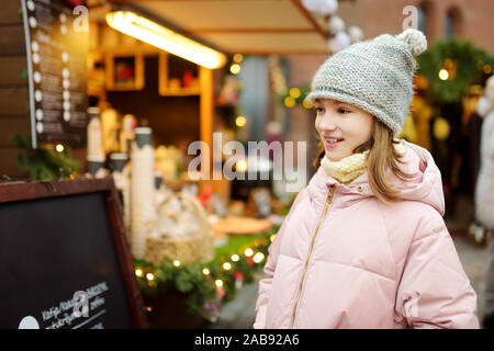 Junge Mädchen Süßigkeiten Auswahl auf den traditionellen Weihnachtsmarkt in Riga, Lettland niedlich. Kid kaufen Candy und Cookies auf Weihnachten. Happy Family Zeit an kühlen Win Stockfoto