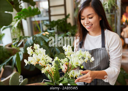 Asiatische Blumenhändler in der Ausbildung mit einem Blumenarrangement Stockfoto