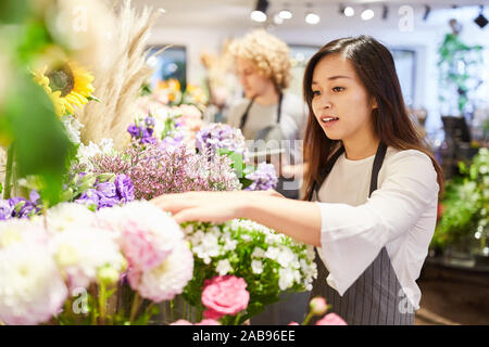 Asiatische Frau als Florist in der Ausbildung in der Pflege von Schnittblumen Stockfoto