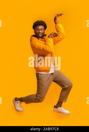 Winter schwarzer Mann tanzen in Ägypten Stil auf orangefarbenem Hintergrund Stockfoto