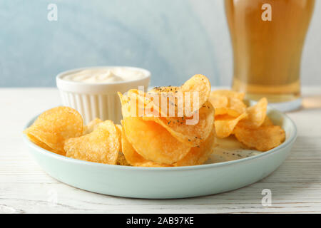 Kartoffelchips und ein Glas Bier. Bier, Snacks, Sauce auf weißem Hintergrund Holz, Platz für Text Stockfoto