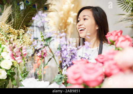 Lächelnden jungen Floristen mit Auswahl von frischen Blumen in Flower Shop Stockfoto