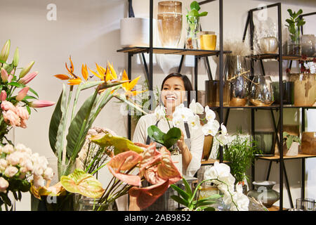 Jungen asiatischen Florist zwischen bunten Blumen im Blumenladen Stockfoto