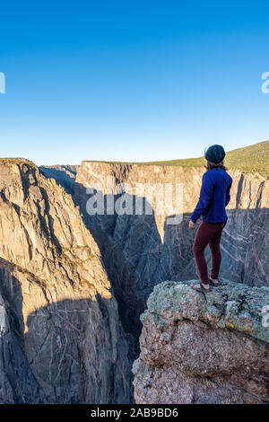 Schöne Frau macht Handstand an der schwarzen Schlucht des Gunnison Stockfoto