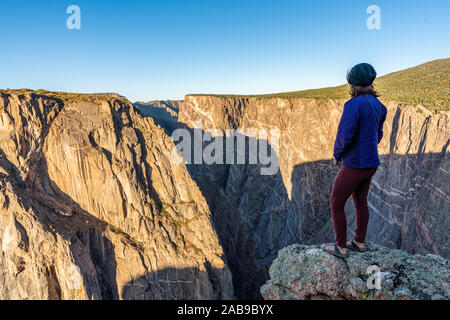 Schöne Frau macht Handstand an der schwarzen Schlucht des Gunnison Stockfoto