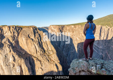 Schöne Frau macht Handstand an der schwarzen Schlucht des Gunnison Stockfoto