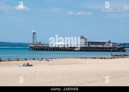 Boscombe Beach in der Nähe von Bournemouth, Dorset an einem hellen Sommertag mit Blick auf Bournemouth Pier im Hintergrund Stockfoto