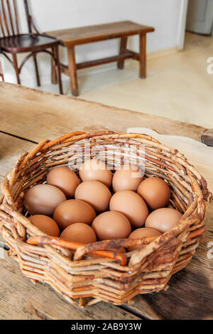 Eier in einem Handwerk antike Korb auf einem hölzernen Tisch sind bereit für die Lackierung für die Osterferien. Stockfoto