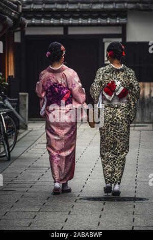 Kyoto, Japan - Oktober 2018: Zwei junge japanische Frauen auf der Straße tragen traditionellen Kimonos. Stockfoto