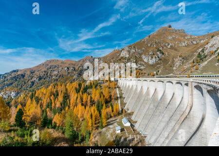 Buntes Bild der beeindruckende Stausee Staudamm am Fedaia See in Südtirol im Herbst mit gelb gefärbte Bäume Stockfoto