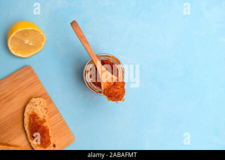 Hausgemachte Karotte Marmelade mit Zitrone und Toast auf hellblau Tabelle. Stockfoto