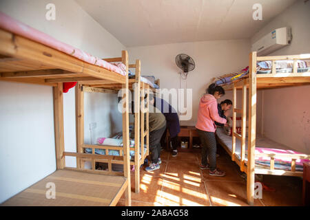 (191119) - NANCHANG, November 26, 2019 (Xinhua) - Er Runmei (2., L) reinigt ein Wohnheim mit Studenten in Sanlian Sonderschule in Nanchang, der ostchinesischen Provinz Jiangxi, Nov. 22, 2019. Er Xingwu, hörgeschädigt, ist ein Lehrer in Sanlian Sonderschule gegründet im Jahr 1994. Fünf Jahre später, die Gründer verstorben. Aus Gründen der Anhörung - der sehbehinderten Kindern den Zugang zu Bildung, Er bestimmt alle Verantwortlichkeiten innerhalb der Schule zu übernehmen. Seine Frau, die er Runmei, auch Hörgeschädigte, widmete sich die Schule und begann Pflege des täglichen Lebens der Kinder zu nehmen. Considerin Stockfoto